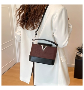 Detail of two-tone brown suede and black leather shoulder bag with golden V-logo hardware