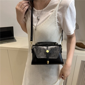 Chic black mini crossbody bag with gold hardware and top handle for women