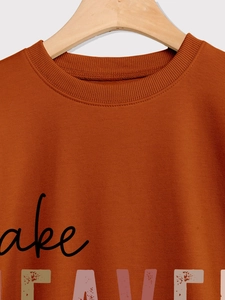 Close-up of rust red sweatshirt neckline featuring vintage artistic graphic and soft texture
