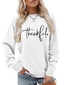 Detail of thankful script print and small heart on white crewneck sweatshirt fabric