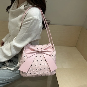 Pink quilted shoulder bag with large bow and black polka dots for stylish commuting