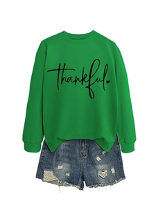 Flat lay of green 'thankful' sweatshirt with heart print and ripped denim shorts