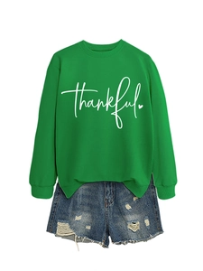 Flat lay of green cotton sweatshirt with thankful print and distressed denim shorts