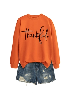 Flat lay of an orange thankful sweatshirt paired with distressed blue denim shorts