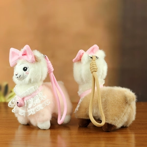 Close-up of plush alpaca keychains with pink bows, lace collars and jingling bells