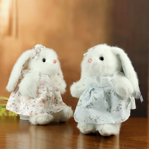 Coppia di coniglietti di peluche con abiti in pizzo floreale rosa e blu su legno