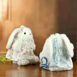 Dettaglio di coniglietti di peluche in abiti di pizzo floreale con perle e ganci di attacco
