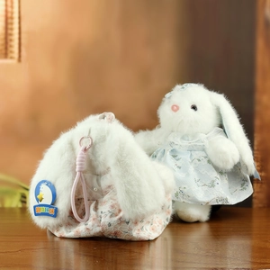 Dettaglio del coniglio di peluche a orecchie lunghe con vestito in pizzo e borsa floreale