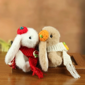 Close-up of cute plush wedding bunnies with knitted hats and scarves on wooden base