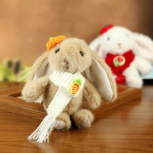 Detailed view of plush bunny with orange carrot hat and white knitted scarf accessory
