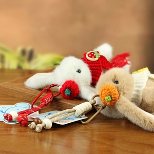 Detailed view of plush rabbit keychains with knitted scarves and handmade braided cords