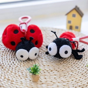Simpatici ciondoli portachiavi in peluche a forma di insetto con occhi grandi su tappeto