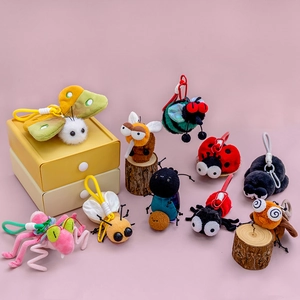 Set di ciondoli in peluche a forma di insetti colorati con farfalle e coccinelle su legno