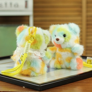 Detail of colorful tie-dye teddy bear plush charm with lace collar and yellow wrist strap