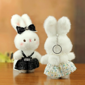 Detailed view of plush bunny keychains with tweed skirts and elegant pearl bow accents
