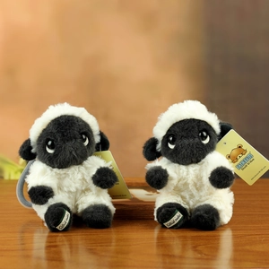 Pair of plush Valais Blacknose sheep toys on wooden table for home gift decoration