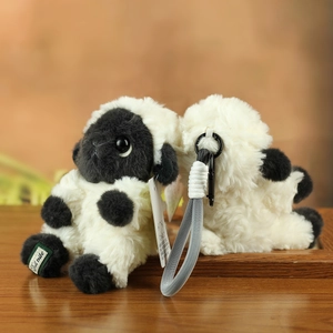 Macro detail of the plush sheep keychain with soft fur, metal ring and brand woven label