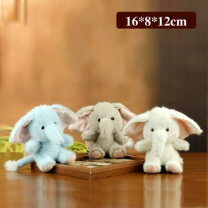 Three plush elephant keychains in blue, gray, and white standing on a wooden frame