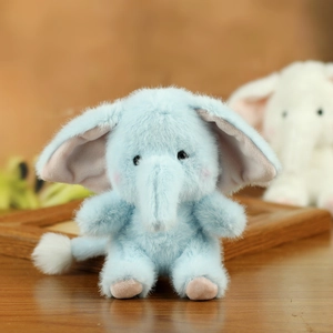 Close-up of soft light blue plush elephant keychain with fluffy ears and pink paws