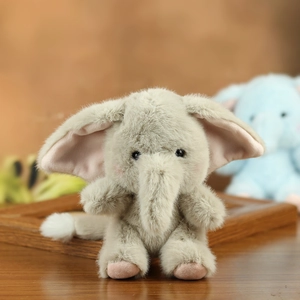 Close-up of soft grey plush elephant keychain with pink ears and fluffy texture