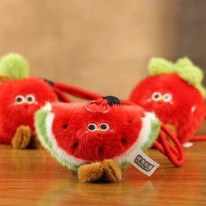 Gros plan du porte-clés pastèque en peluche avec visage brodé et attache en plastique