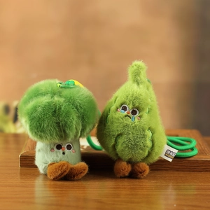 Gros plan de pendentifs en peluche brocoli et poire avec broderies et texture douce