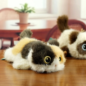 Close-up of tricolor plush cat toy with gold-rimmed eyes on a natural wooden table