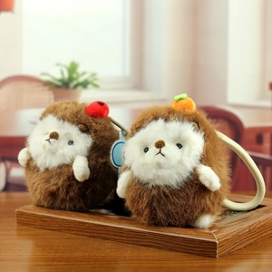 Adorable hedgehog plush keychain set with apple and carrot charms on wooden background