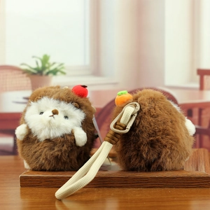 Front and back detail of plush hedgehog charms with mini apple and carrot decorations