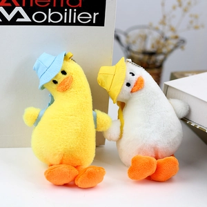Detail of yellow and white plush duck pendants wearing colorful hats and backpacks