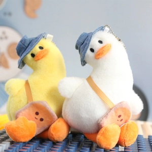 Close-up of cute plush duck keychain with denim hat and orange crossbody bag