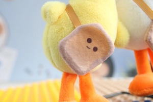Detail of cute yellow plush duck showing the decorative mini toast crossbody bag accessory