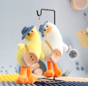 Detailed view of plush duck keychains with blue hats and tiny toast crossbody bags