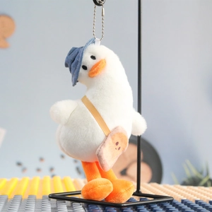 Detail of plush duck keychain with blue denim hat and small toast crossbody bag accessory