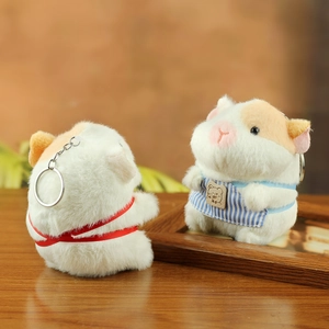 Close-up of cute plush guinea pig charms with blue apron and red ribbon details