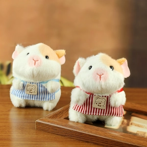 Cute hamster plush keychain with striped apron on a wooden table, soft stuffed toy