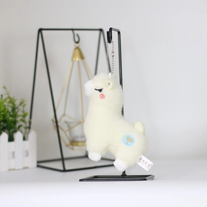 Cute alpaca plush keychain in cream white with Aries embroidery on a metal stand