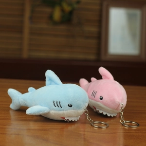 Macro detail of blue and pink plush shark keychains with embroidered eyes and silver metal rings