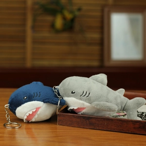 Detail shot of two plush shark keychains in blue and gray colors with silver keyrings