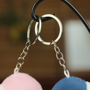 Close-up of durable metal keyrings and chains on blue and pink plush shark pendants