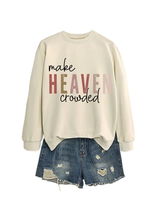 Flat lay of cream 'make HEAVEN crowded' sweatshirt paired with distressed denim shorts