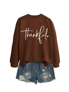 Detail of thankful heart print on brown sweatshirt paired with distressed denim shorts