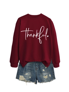 Detail of burgundy crewneck sweatshirt with thankful print and distressed denim shorts