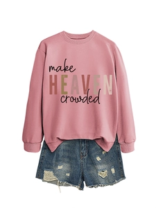 Flat lay of pink sweatshirt with 'make HEAVEN crowded' text and ripped denim shorts