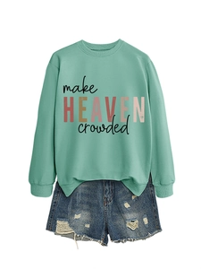 Flat lay of light green sweatshirt with make heaven crowded print and ripped denim shorts