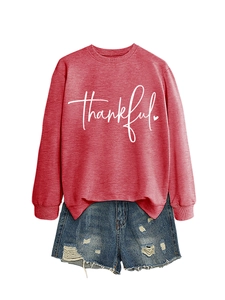 Detail of red thankful sweatshirt with heart print and distressed denim shorts
