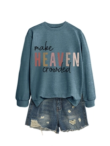Flat lay of blue-grey sweatshirt with make HEAVEN crowded text and ripped denim shorts