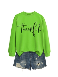 Detail of lime green sweatshirt with 'Thankful' script and heart print in casual style