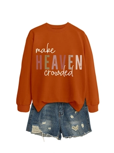 Flat lay of burnt orange sweatshirt with make HEAVEN crowded text and denim shorts