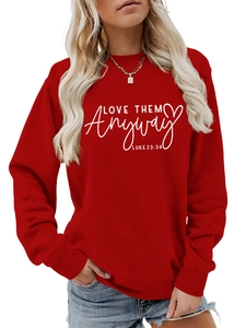 Detail of red crewneck sweatshirt featuring white LOVE THEM ANYWAY text and ribbed cuffs